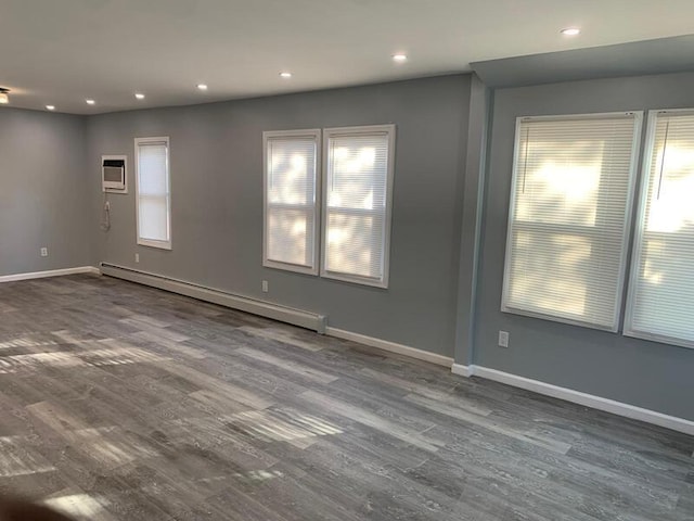 158-04 111th Ave, Jamaica, NY 11433 - empty room with a baseboard heating unit, wood finished floors, baseboards, recessed lighting, and an AC wall unit
