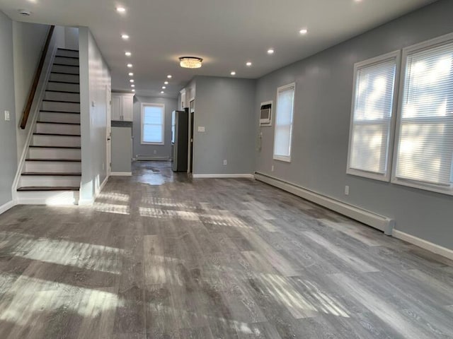 158-04 111th Ave, Jamaica, NY 11433 - unfurnished living room with baseboard heating, baseboards, wood finished floors, recessed lighting, and stairs