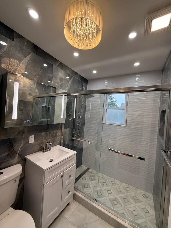 158-04 111th Ave, Jamaica, NY 11433 - full bathroom featuring toilet, vanity, a shower stall, tile walls, and marble look tiles