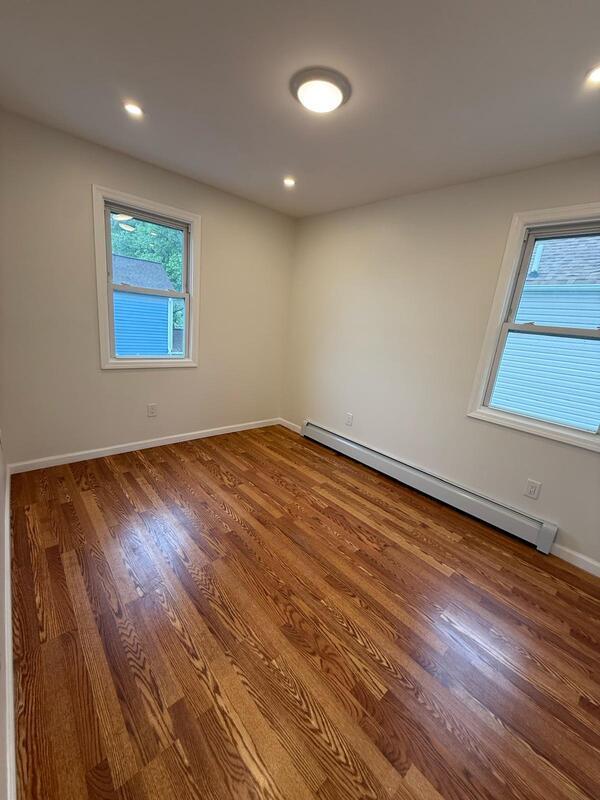 158-04 111th Ave, Jamaica, NY 11433 - spare room with a baseboard radiator, plenty of natural light, wood finished floors, and recessed lighting