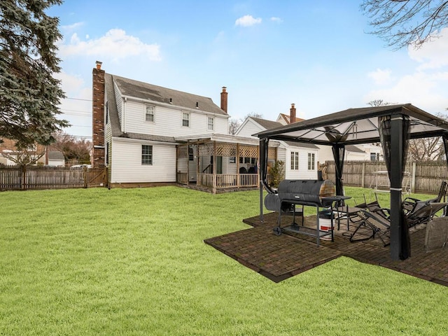rear view of house with a gazebo, a chimney, and a patio area