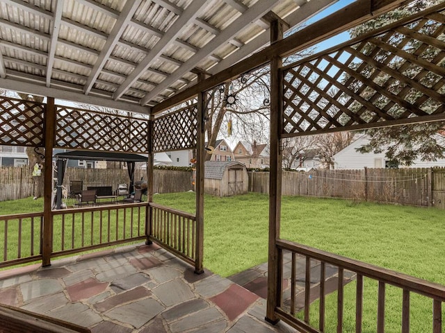 wooden deck with a storage shed, an outbuilding, a patio area, and a gazebo