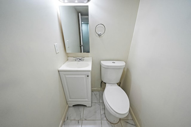 bathroom featuring baseboards, vanity, and toilet