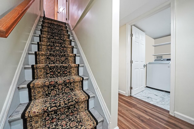 staircase featuring washer / dryer, wood finished floors, and baseboards