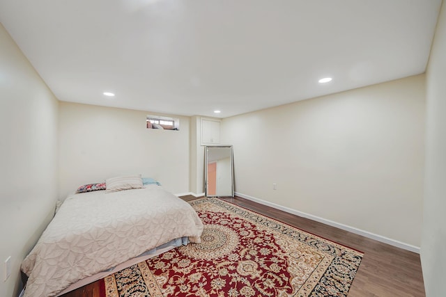 bedroom with wood finished floors, baseboards, and recessed lighting