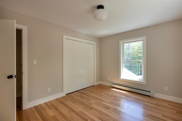 1531 Glasco Tpke, Saugerties, NY 12498 - unfurnished bedroom featuring a baseboard heating unit, light wood-style floors, baseboards, and a closet