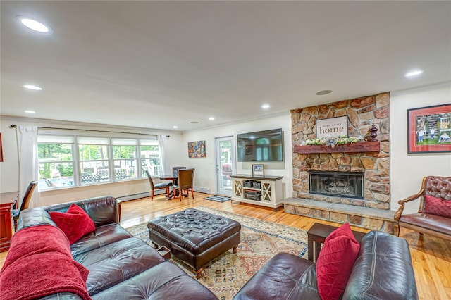 living room with crown molding, wood finished floors, a fireplace, baseboard heating, and recessed lighting