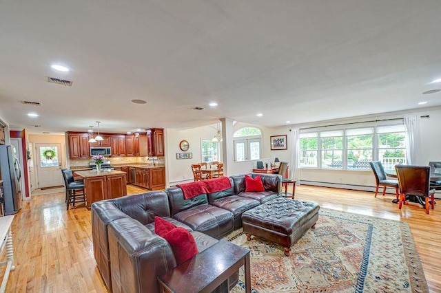 living room featuring light wood-style flooring, recessed lighting, and baseboard heating