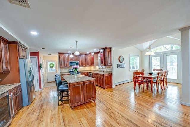 kitchen with appliances with stainless steel finishes, baseboard heating, wine cooler, light wood-style floors, and french doors