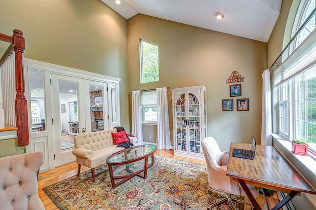 living room featuring high vaulted ceiling and light wood finished floors