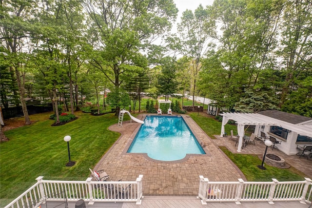 swimming pool with a deck, a water slide, a fire pit, and a lawn