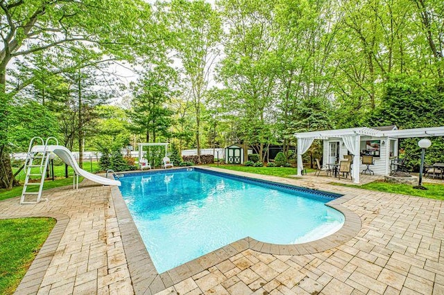 view of pool featuring a water slide, a pergola, a patio, an outdoor structure, and a storage unit