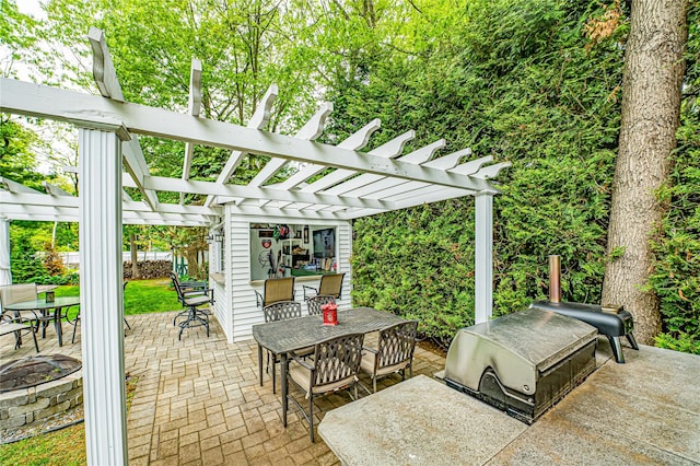 view of patio featuring outdoor dining space, a pergola, and grilling area