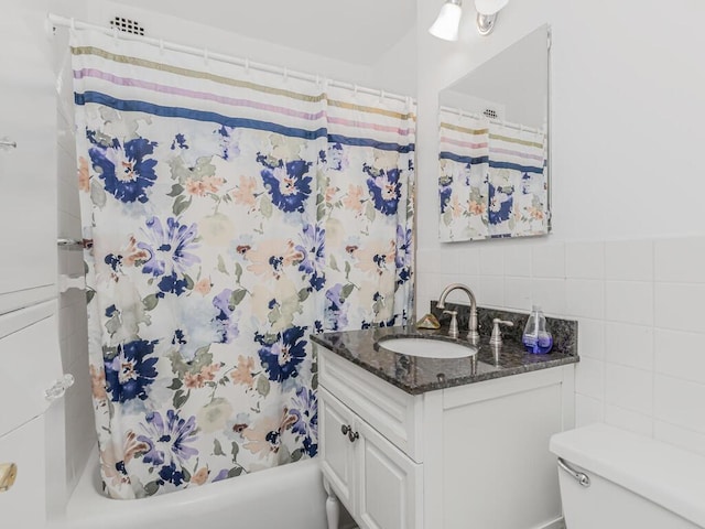 bathroom with tile walls, vanity, toilet, and shower / tub combo with curtain