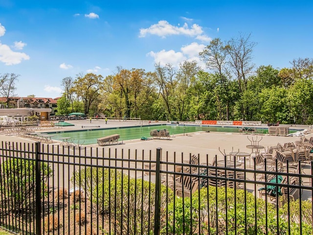 community pool with fence and a patio
