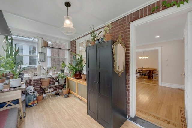 5749 Faraday Ave, Bronx, NY 10471 - kitchen with light wood finished floors, crown molding, baseboards, a chandelier, and hanging light fixtures