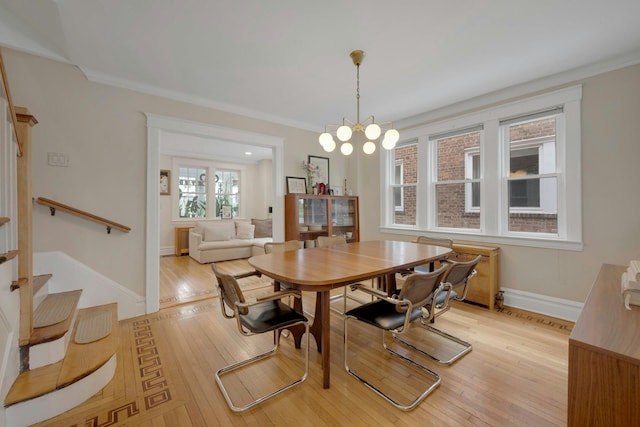 5749 Faraday Ave, Bronx, NY 10471 - dining room featuring light wood-style flooring, baseboards, stairway, ornamental molding, and a chandelier
