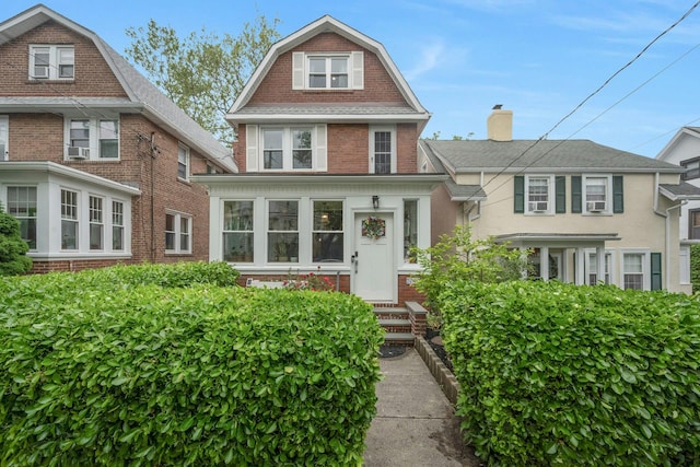 5749 Faraday Ave, Bronx, NY 10471 - view of front of house with brick siding, a gambrel roof, and cooling unit