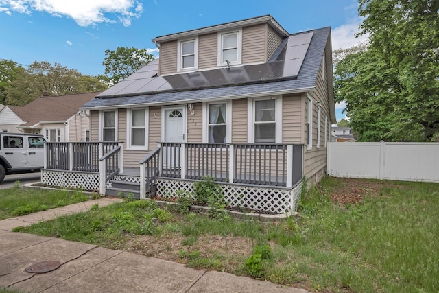 253 N 3rd Ave, Bay Shore, NY 11706 - view of front of property with fence, a shingled roof, solar panels, and covered porch