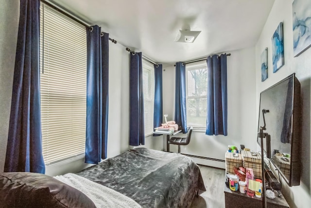 253 N 3rd Ave, Bay Shore, NY 11706 - bedroom featuring baseboard heating and wood finished floors