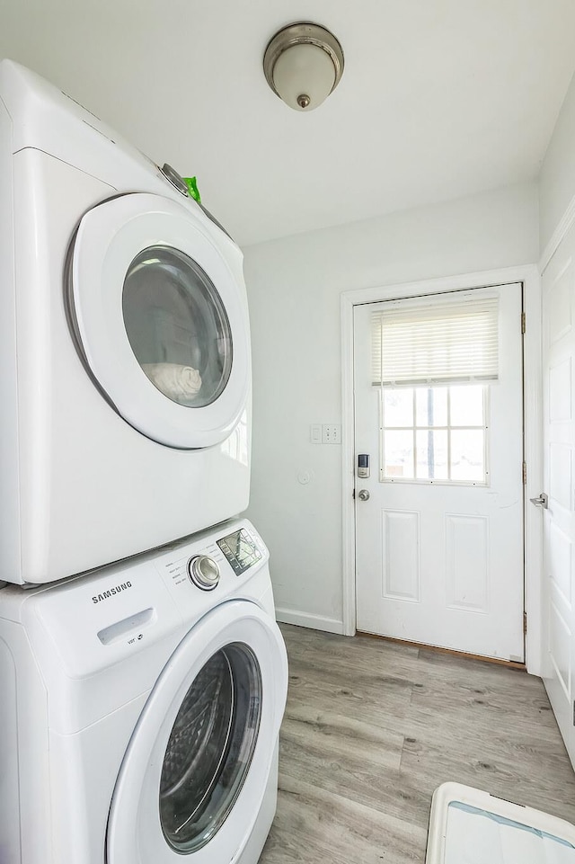253 N 3rd Ave, Bay Shore, NY 11706 - washroom featuring stacked washer / drying machine, light wood-style flooring, and baseboards