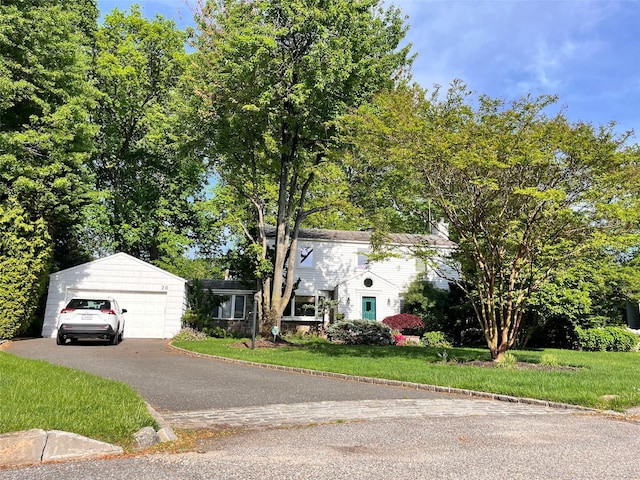 view of front of house with a front yard and a detached garage