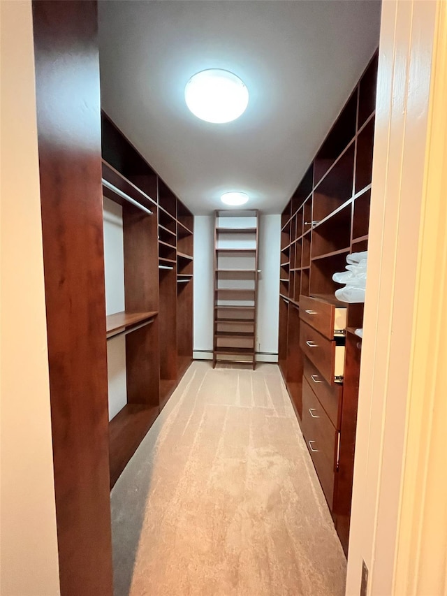 spacious closet with a baseboard radiator and carpet flooring