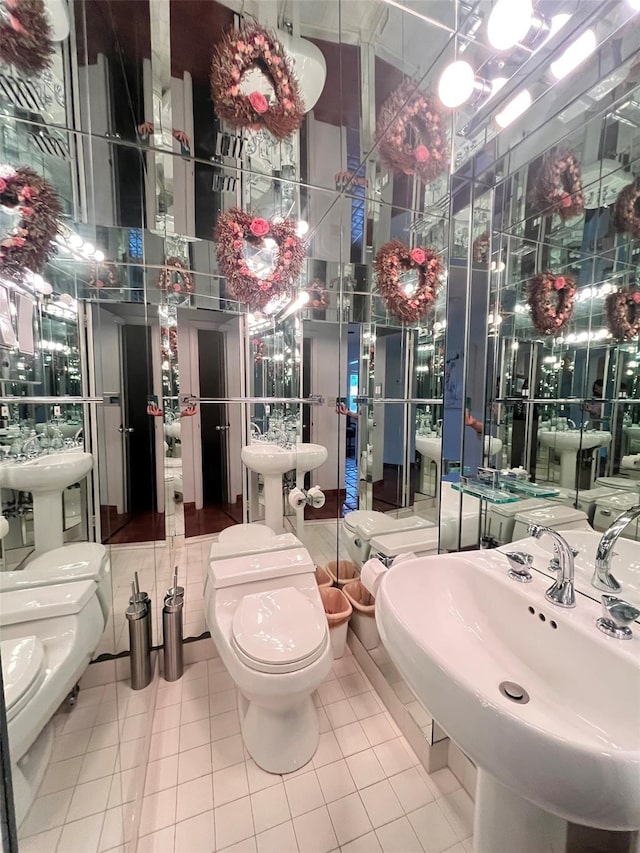 bathroom featuring tile patterned flooring, toilet, and a sink