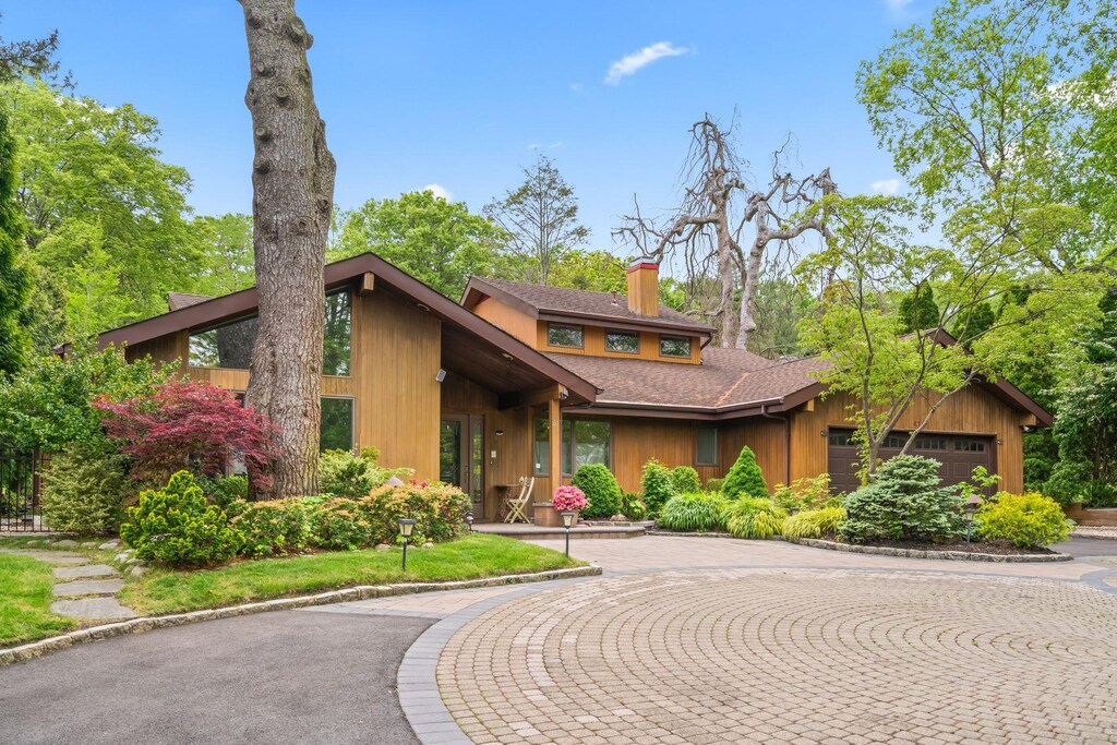 67 Karol Pl, Muttontown, NY 11753 - mid-century home with a chimney, an attached garage, roof with shingles, and curved driveway