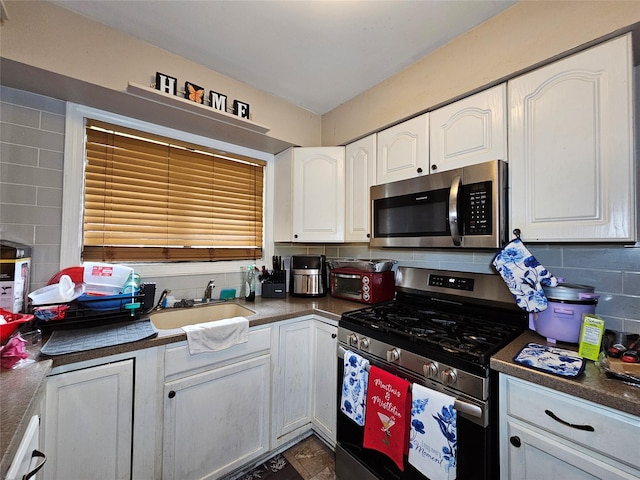 3 Allan Park Mews, Middletown, NY 10940 - kitchen featuring appliances with stainless steel finishes, dark countertops, white cabinetry, a sink, and tasteful backsplash