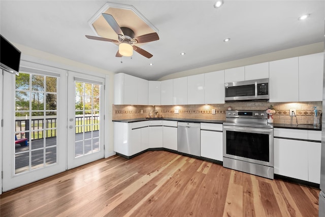 kitchen featuring stainless steel appliances, dark countertops, tasteful backsplash, a sink, and recessed lighting