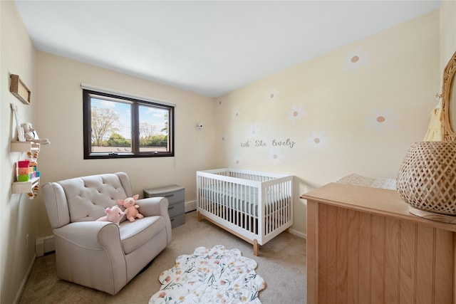 bedroom with light carpet, baseboards, a baseboard radiator, and a nursery area