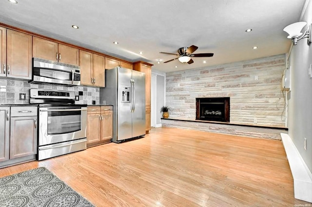 kitchen with appliances with stainless steel finishes, ceiling fan, dark countertops, light wood-style flooring, and recessed lighting