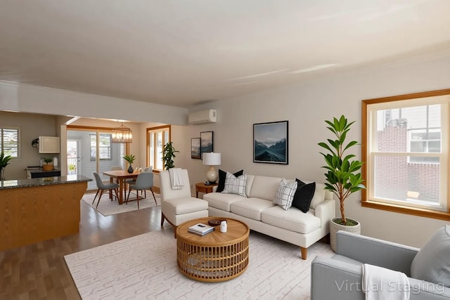 living room with a wall mounted air conditioner, dark wood-style flooring, a chandelier, and crown molding