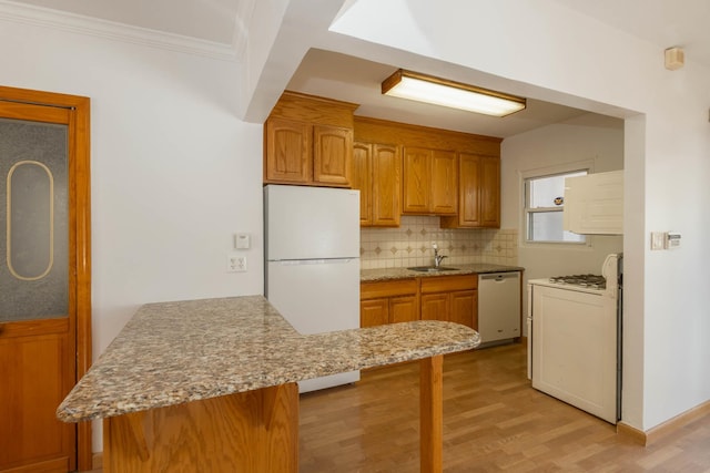 kitchen with dishwasher, a sink, a peninsula, freestanding refrigerator, and range with gas cooktop