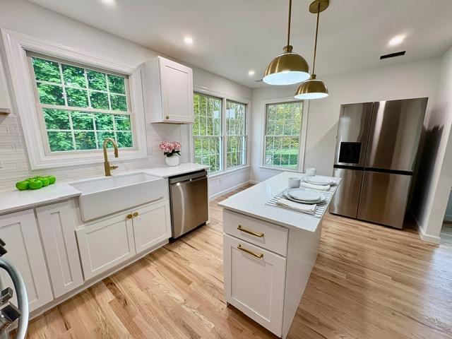 2850 Reeve Rd, Mattituck, NY 11952 - kitchen with appliances with stainless steel finishes, a sink, light countertops, light wood-type flooring, and white cabinets
