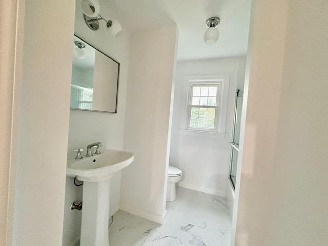 2850 Reeve Rd, Mattituck, NY 11952 - full bath with toilet, marble finish floors, baseboards, and a sink