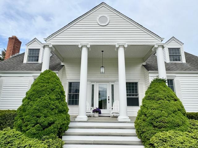 2850 Reeve Rd, Mattituck, NY 11952 - view of front of property featuring a porch, a shingled roof, and a chimney