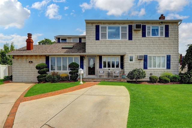 view of front of property featuring a chimney, a front lawn, and a wall mounted AC