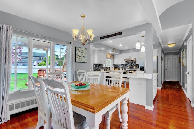 dining area featuring dark wood-style floors, a chandelier, baseboards, and plenty of natural light