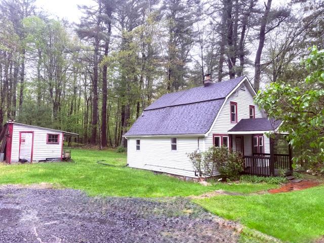38 Eldred Yulan Rd, Eldred, NY 12732 - view of property exterior featuring a yard, an outdoor structure, a chimney, a porch, and roof with shingles