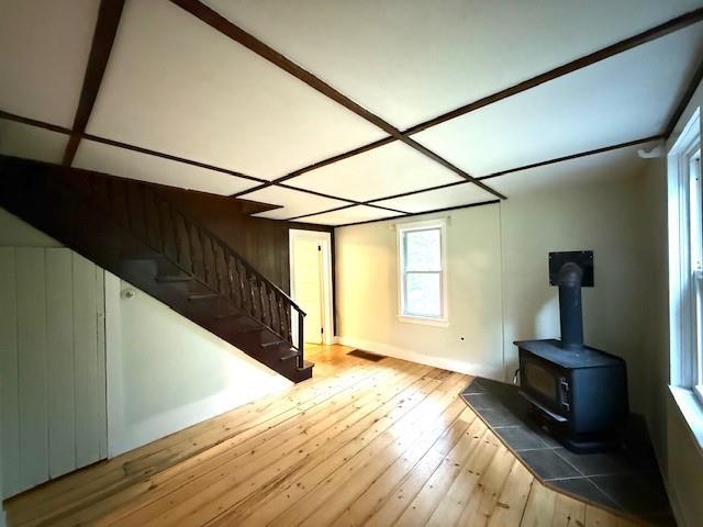 38 Eldred Yulan Rd, Eldred, NY 12732 - unfurnished living room with wood-type flooring, stairway, and a wood stove