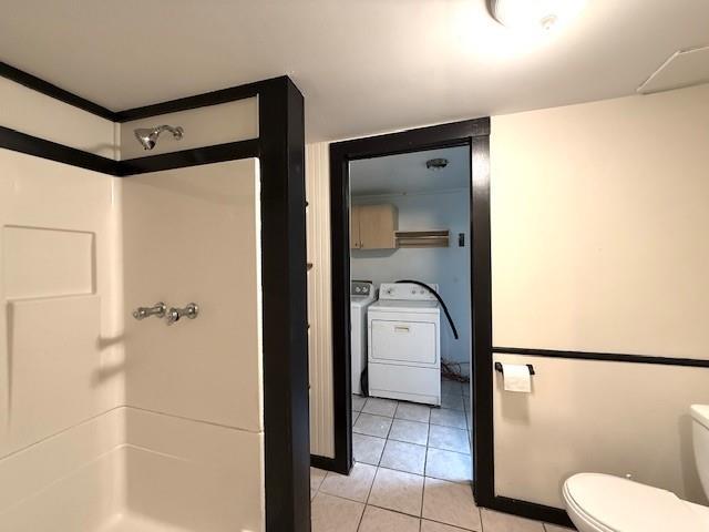 38 Eldred Yulan Rd, Eldred, NY 12732 - bathroom with a stall shower, toilet, washer and dryer, and tile patterned floors