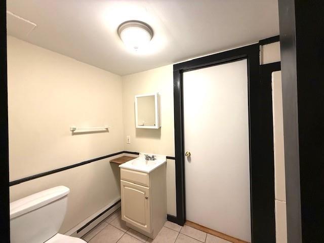 38 Eldred Yulan Rd, Eldred, NY 12732 - half bath with a baseboard radiator, toilet, tile patterned flooring, and vanity