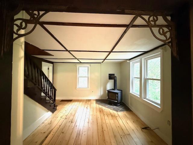 38 Eldred Yulan Rd, Eldred, NY 12732 - unfurnished living room with a wood stove, plenty of natural light, hardwood / wood-style floors, and stairway