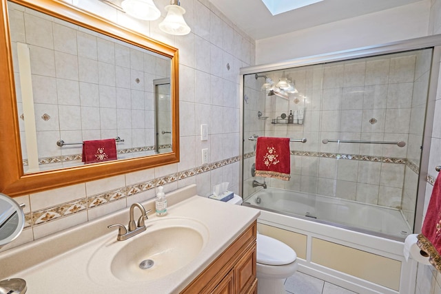 27 Amby Ave, Plainview, NY 11803 - full bathroom with tile walls, toilet, vanity, combined bath / shower with glass door, and a skylight
