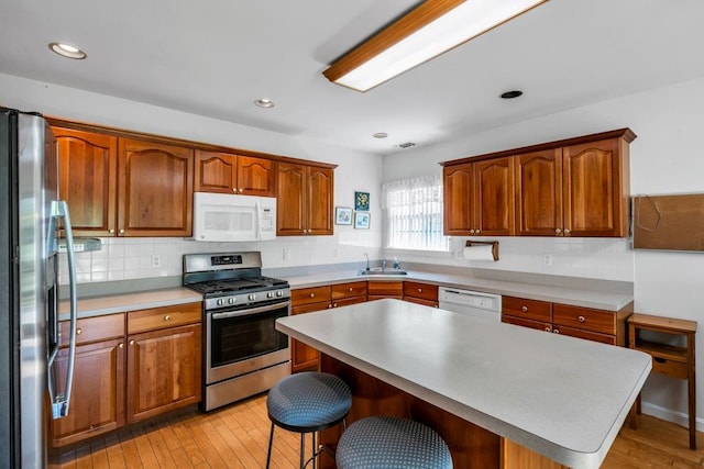 30 Julia Cir, Middle Island, NY 11953 - kitchen with appliances with stainless steel finishes, a sink, a kitchen breakfast bar, tasteful backsplash, and recessed lighting