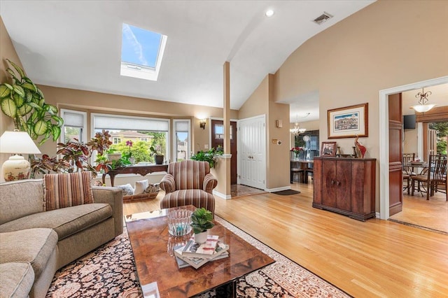 26 Tioga Dr, Jericho, NY 11753 - living room with vaulted ceiling, light wood-style flooring, a skylight, and baseboards