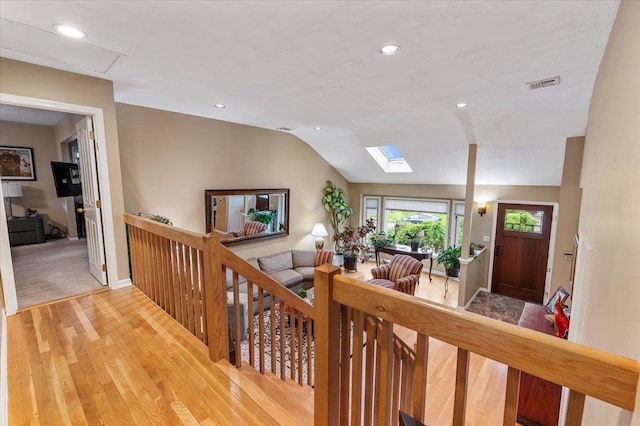 26 Tioga Dr, Jericho, NY 11753 - corridor featuring wood finished floors, an upstairs landing, lofted ceiling, a skylight, and recessed lighting