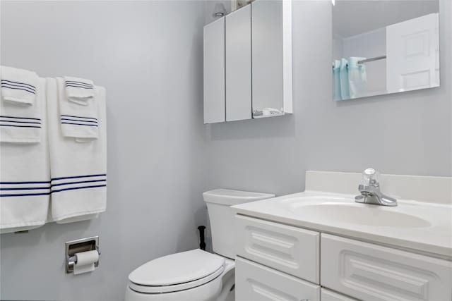 bathroom with toilet, vanity, and a shower with curtain